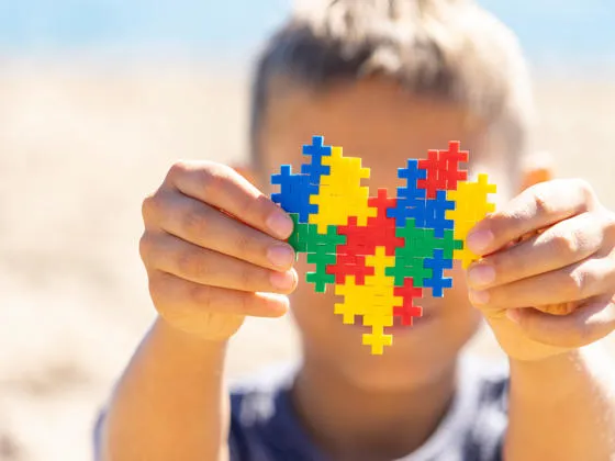Child holding a heart shaped jig-saw