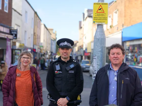Dau berson a swyddog o'r Heddlu ar stryd Caernarfon