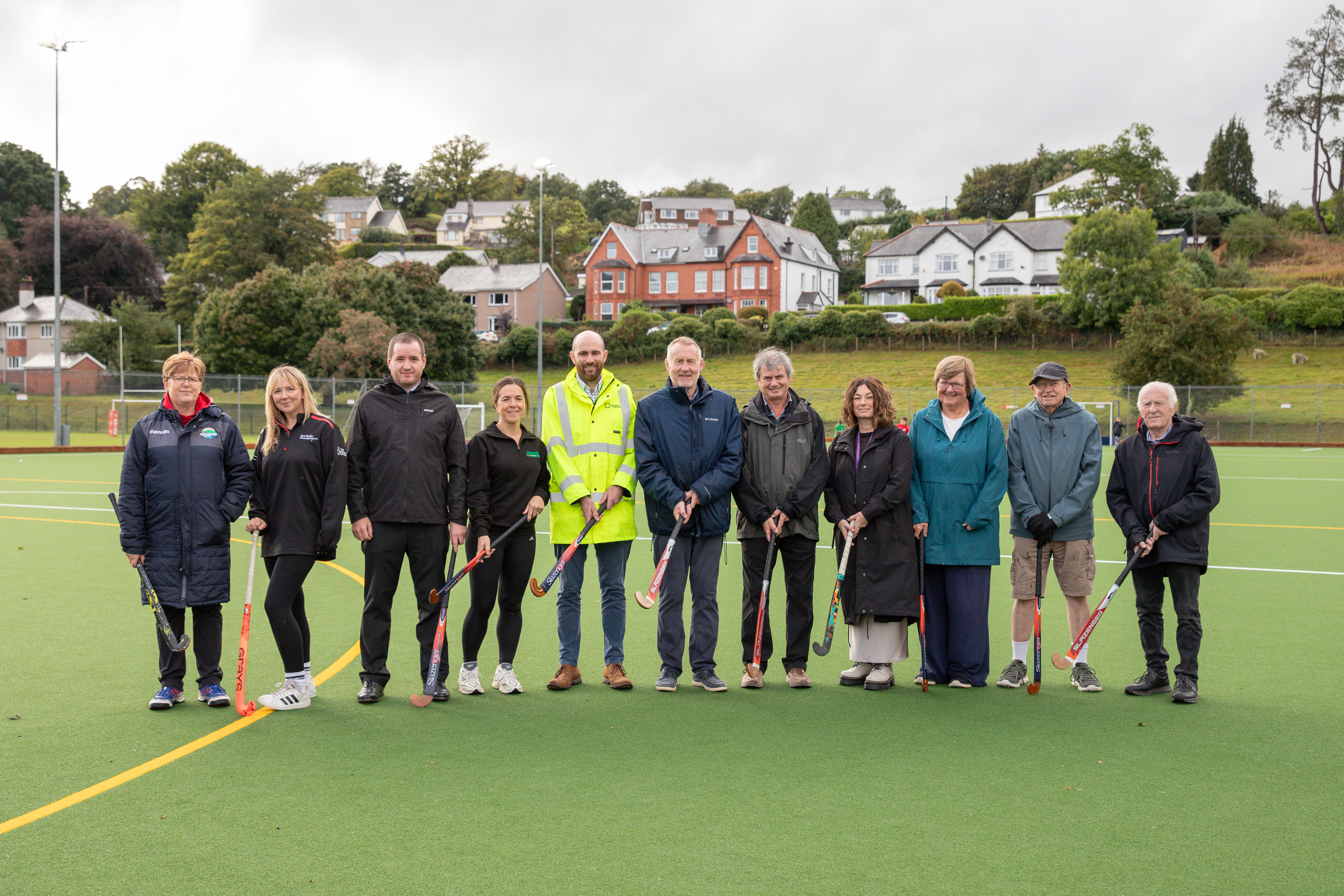 Group of people of hockey field with hockey sticks