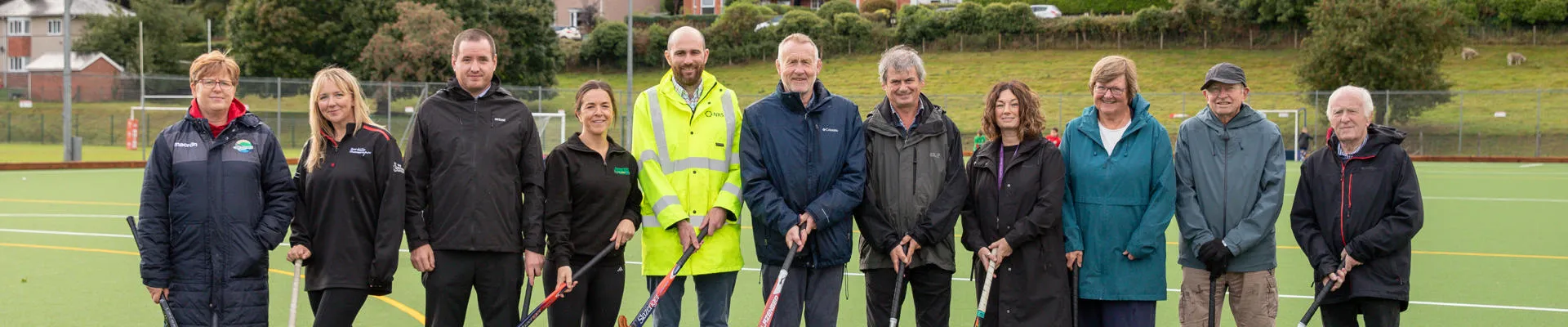 Group of people of hockey field with hockey sticks