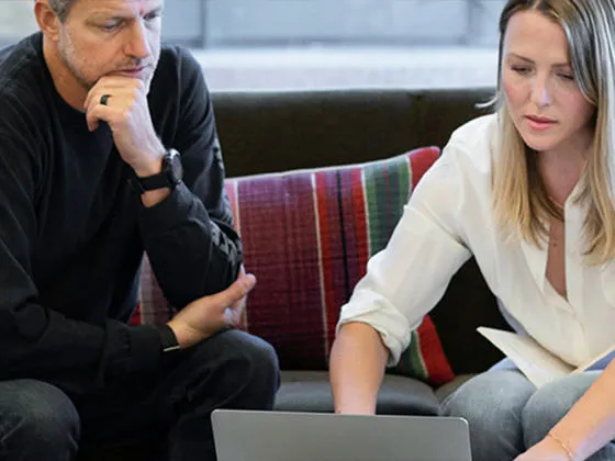 Two people looking at a laptop