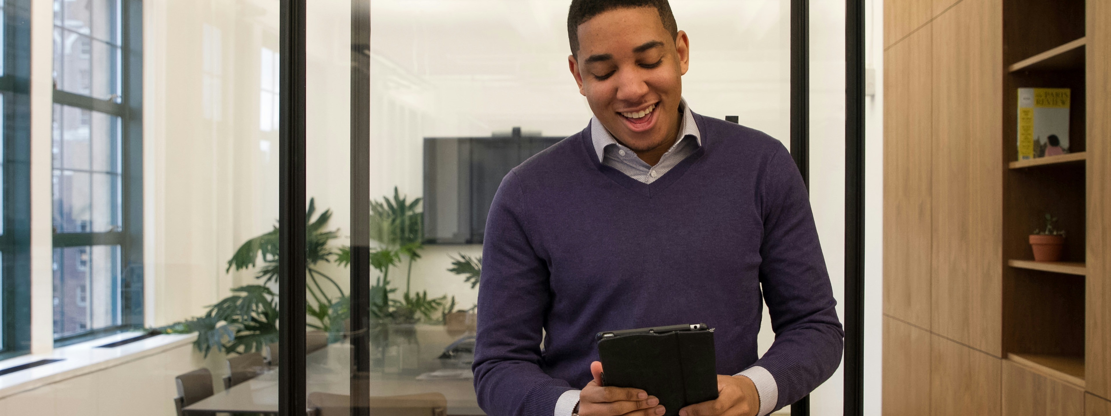 Man smiilng looking at tablet
