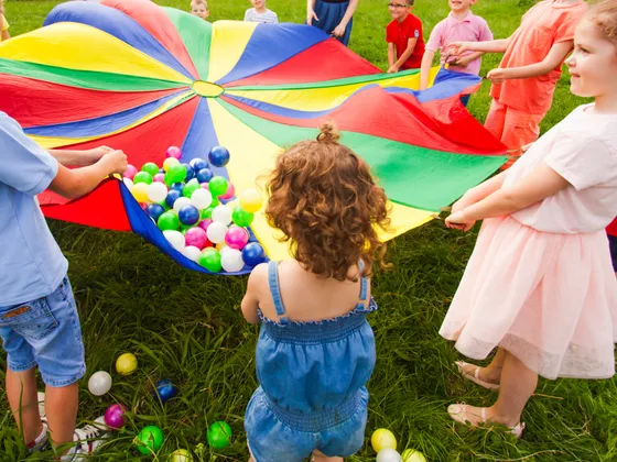 Young children playing with parachute and balls